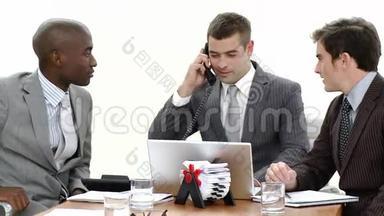 在<strong>一次会议</strong>上用笔记本电脑和电话交谈的商人